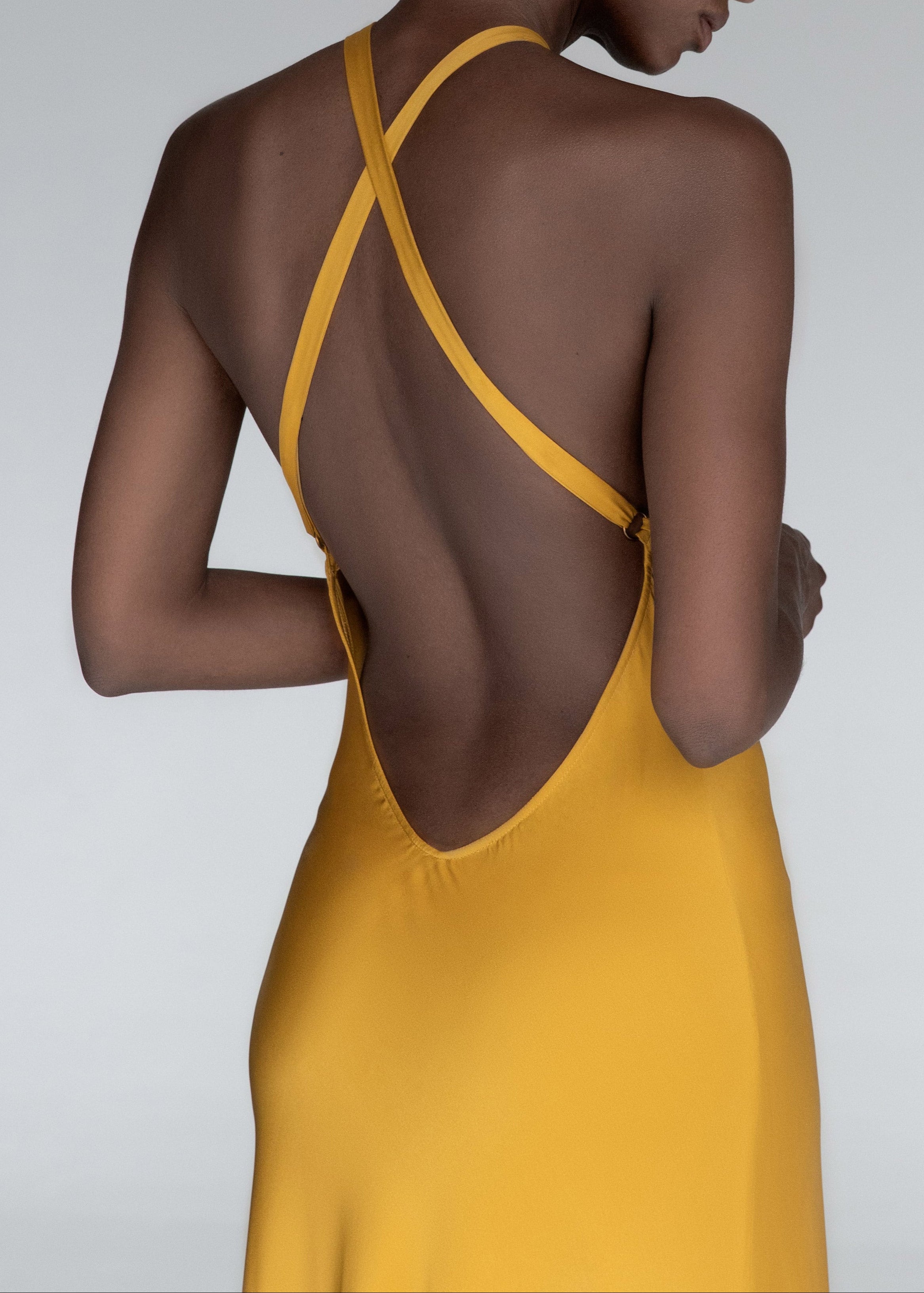 Model wears yellow silk halteneck evening dress